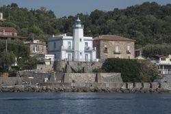 Il pittoresco faro del villaggio di Scario, provincia di Salerno, Campania. Attivato nel 1883, questo faro sorge in località Tragara fra alcune abitazioni d'epoca che si rispecchiano ...