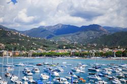 Il porto e la spiaggia di Sestri Levante, Liguria. Il porto è formato da due pontili e un molo che si estende verso nord per circa 250 metri. 
