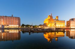 Il porto interno di Duisburg illuminato di notte e riflesso nell'acqua, Germania.

