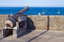 Il tetto del museo nella città di Le Palais, Belle Ile en Mer, con un vecchio cannone e un gabbiano appollaiato sul muro in pietra.

