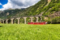 Il trenino rosso del Bernina Express sotto il viadotto, Svizzera.
