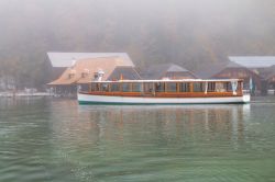 Un'imbarcazione turistica sul lago Konigssee con la nebbia, Berchtesgaden National Park, Germania. Sullo sfondo, i monti Watzmann nei pressi del confine fra Germania e Austria.
