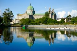 La cattedrale di Galway vista dal fiume Corrib e fotografata di mattina, Irlanda. La sua forma si ispira alle chiese rinascimentali e la cupola verde spicca sulla pietra calcarea grigia con ...