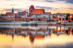 La città di Torun si rispecchia nel fiume Vistola, Polonia. Una bella immagine scattata al tramonto di questa cittadina polacca, importante centro industriale nel settore chimico. E' ...