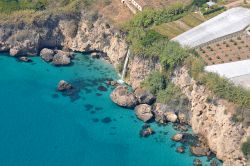 La Costa di Nerja (Spagna) in prossimità del Barranco de Maro, con cascata sul mare