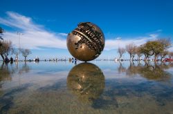 La grande sfera di Arnaldo Pomodoro a Pesaro, Marche, Italia. Adagiato sulla superficie dell'acqua di una fontana da cui si guarda il mare, questo monumento in bronzo è stato realizzato ...