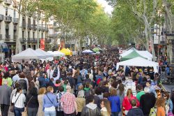 La Rambla durante il giorno di San Giorgio a Barcellona, Spagna. Turisti e residenti a passeggio ne La Rambla, il suggestivo viale cittadino che collega Placa de Catalunya con il porto vecchio. ...