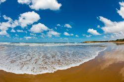 La schiuma delle onde si infrange sulla sabbia di questa spiaggia di Torquay, Australia.
