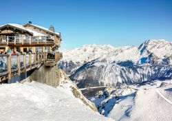 La terrazza di un ristorante in cima alla stazione sciistica di Courchevel (Francia) con le piste innevate.



