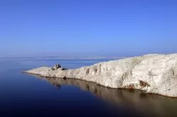 il Mare di Pag in Croazia (Pago): bianche rocce calcaree lungo la costa settentrionale della lunga isola dellla Dalmazia. Si notano le rovine di un antico faro che serviva questo tratto di costa ...