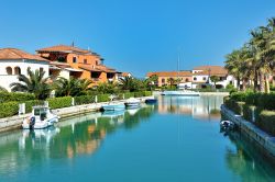 Marina di Policoro, Basilicata: barche ormeggiate e palazzi eleganti che si rispecchiano nell'acqua.
