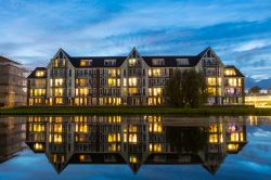 Moderni appartamenti residenziali riflessi in un canale by night a Haarlem, Olanda.

