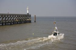 Molo a Blankenberge, Belgio. Un grazioso faro si innalza alla fine del molo cittadino circondato dalle acque del mare del Nord.
