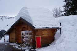 Neve sul tetto di una casetta in legno nello ski resort di Les Gets, Francia.

