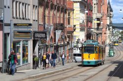 Norrkoping, una via del centro storico con gente a passeggio e un tram (Svezia) - © Tupungato / Shutterstock.com