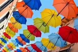 Ombrelli colorati decorano una strada dello shopping nella città vecchia di Novigrad, Croazia.

