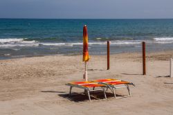 Ombrellone e sdraio sulla spiaggia deserta di Laigueglia, Liguria.




