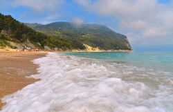 Onde sul mare limpido della spiaggia di Sirolo nelle Marche, penisola del Conero