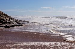 Onde sulla spiaggia di Areia Branca a Lourinha, Portogallo. Questa località sulla costa ovest del Portogallo è abitata da tempi immemorabili.

