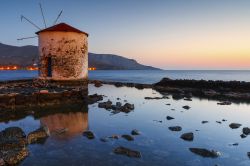 Paesaggio al tramonto con mulino a vento nel paese di Agia Marina, isola di Lero, Grecia.
