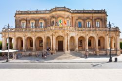 Palazzo Ducezio, sede del Municipio di Noto, in un soleggiato giorno d'estate - Palazzo Ducezio, attualmente sede del Municipio di Noto, è un bellissimo edificio costruito, in stile ...