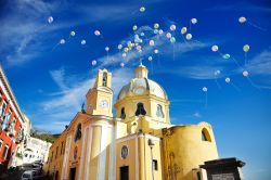 Palloncini colorati nel cielo sopra una chiesa di Procida, baia di Napoli, Campania.

