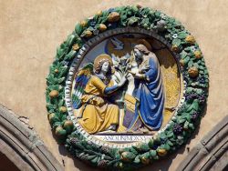 Particolare della facciata dell'Ospedale del Ceppo a Pistoia, Toscana - Il tondo decorativo in cui l'arcangelo Gabriele annuncia a Maria il concepimento del Salvatore. Sotto si possono ...