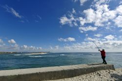 Un pescatore sul bordo dell'oceano a Esposende, Portogallo. Sullo sfondo, la sabbia del Parco Naturale del Litorale Nord - © Rafal Gadomski / Shutterstock.com