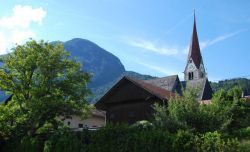 Il campanile della chiesa svetta tra i tetti di Jenbach, Austria - la Pfarrkirche (chiesa parrocchiale) dedicata ai Santi Wolfgang e Leonhard, svetta tra i tetti di Jenbach con il suo bellissimo ...