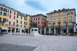 Piazza della Vittoria a Salò, Lombardia. Palazzi e edifici dalle facciate color pastello si affacciano su Piazza della Vittoria, principale area urbanistica della città - © ...