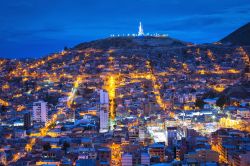 Una pittoresca veduta dall'alto by night di Oruro, Bolivia, con la statua della Madonna del Socavon sullo sfondo.
