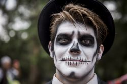 Un ragazzo con il volto pitturato partecipa al desfile del Día de Muertos a Città del Messico.
