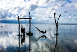 Riflessi sull'acqua a Gili Trawangan (Indonesia): in relax, al calar del sole, su un'amaca e un'altalena. 
