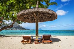Sdraio e ombrelloni sulla spiaggia tropicale, isola di Mauritius - Relax in spiaggia con sdraio e ombrellone di paglia: le acque calde e trasparenti dell'Oceano Indiano e la vegetazione ...