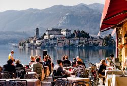 Gente al ristorante a Orta San Giulio, Piemonte, Italia. Con il vicino sito Unesco di Sacro Monte e l'isola di San Giulio, Orta è una popolare meta turistica - © pcruciatti / ...