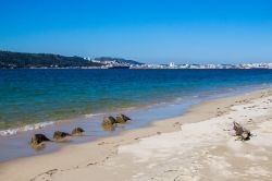 Spiaggia di sabbia nella penisola di Troia, Portogallo. Sullo sfondo la cittadina di Setubal, località di antiche origini con quartieri moderni, centro turistico e porto.
