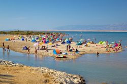 Gente sulla spiaggia della laguna di Ninska a Nin, Dalmazia. Questa laguna si trova nei pressi della cittadina di Nin il cui centro è situato su una piccola isoletta collegata da due ...