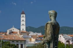 Statua del pescatore di Crikvenica, Croazia. Sullo sfondo, il campanile della chiesa cittadina.
