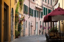 Fra i vicoli del borgo di Cortona, Toscana  - Dimore tinteggiate con i colori pastello, vasi di fiori profumati appesi ai balconi per abbellirne le facciate, infissi in legno dipinti: passeggiando ...