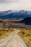 Strada sterrata in pendenza vista dal parabrezza di un autobus in Patagonia, Puerto Natales, Cile. Questa località cilena è situata su una riva del Canal Senoret e offre panorami ...