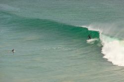 Surfing sulle onde davanti alla spiaggia di Malibu, California.
