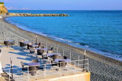 Tavolini e sedie di un locale affacciato sulla spiaggia di Arenzano, provincia di Genova, Liguria.
