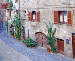 Tipica strada del centro di Bolsena, Italia. Abbellite da fiori e vegetazione, le facciate delle abitazioni di Bolsena si affacciano sulla strada lastricata che attraversa il borgo medievale ...