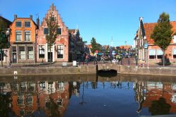 Tipiche case del centro storico riflesse nell'acqua di un canale a Sneek, Olanda.

