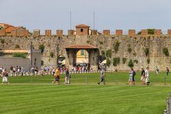 Turisti in Piazza del Duomo a Pisa, Toscana. Conosciuta anche come Piazza dei Miracoli, è il centro artistico e culturale più importante della cittadina toscana. Ospita alcuni ...