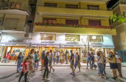 Turisti nel centro storico di Forte dei Marmi di sera, Toscana. Affacciata sul mar Ligure, questa località di villeggiatura prende il nome dall'omonimo fortino che sorge nel cuore ...