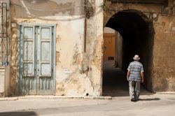 Un anziano signore cammina lungo un vicolo del centro di Marsala, Sicilia.

