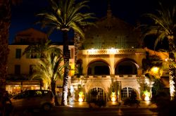 Un edificio con palme illuminato dalle luci della sera a Le Lavandou, Francia - © Spirit Stock / Shutterstock.com