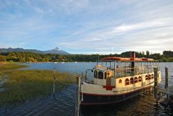 Un pittoresco paesaggio cileno a Pucon con un battello in primo piano e il vulcano Villarrica sullo sfondo - © Niv Koren / Shutterstock.com