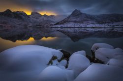 Un pittoresco paesaggio invernale a Svolvaer, Lofoten, Norvegia, con i colori del tramonto riflessi nell'acqua.
